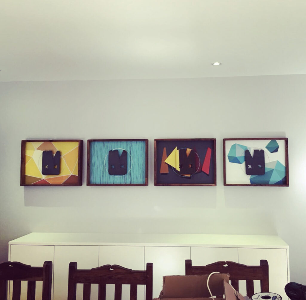 Experts installing a creative gallery wall in a living room