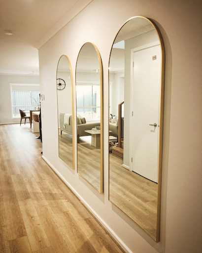 Three large arched mirrors professionally installed in a modern Melbourne hallway by expert mirror hanging service
